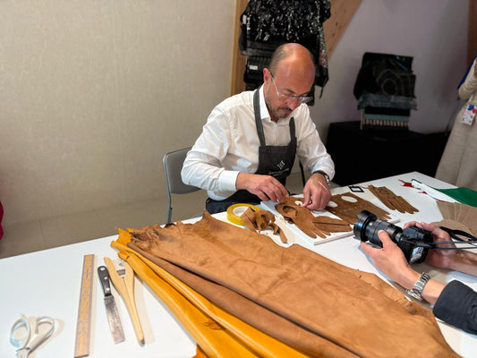 Alessandro Pellone in Gala Gloves apron cutting tan leather with precision tools - documenting Italian artisan expertise at Expo Osaka 2025