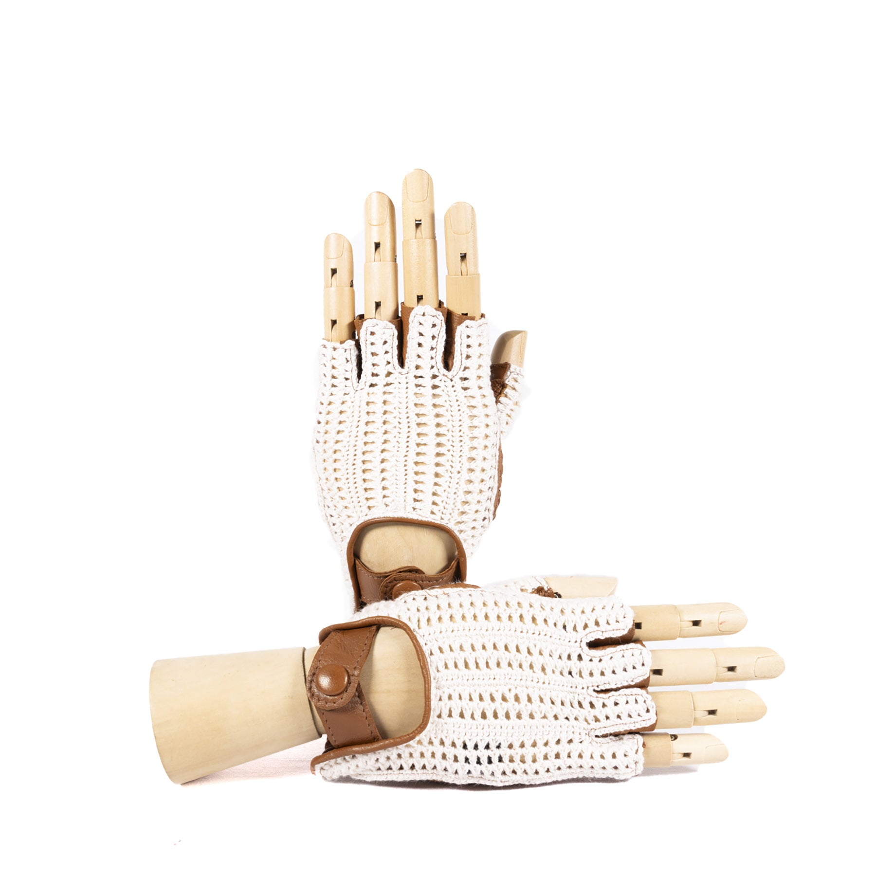 White crochet driving gloves with brown leather accents, elegantly displayed on a wooden hand model.