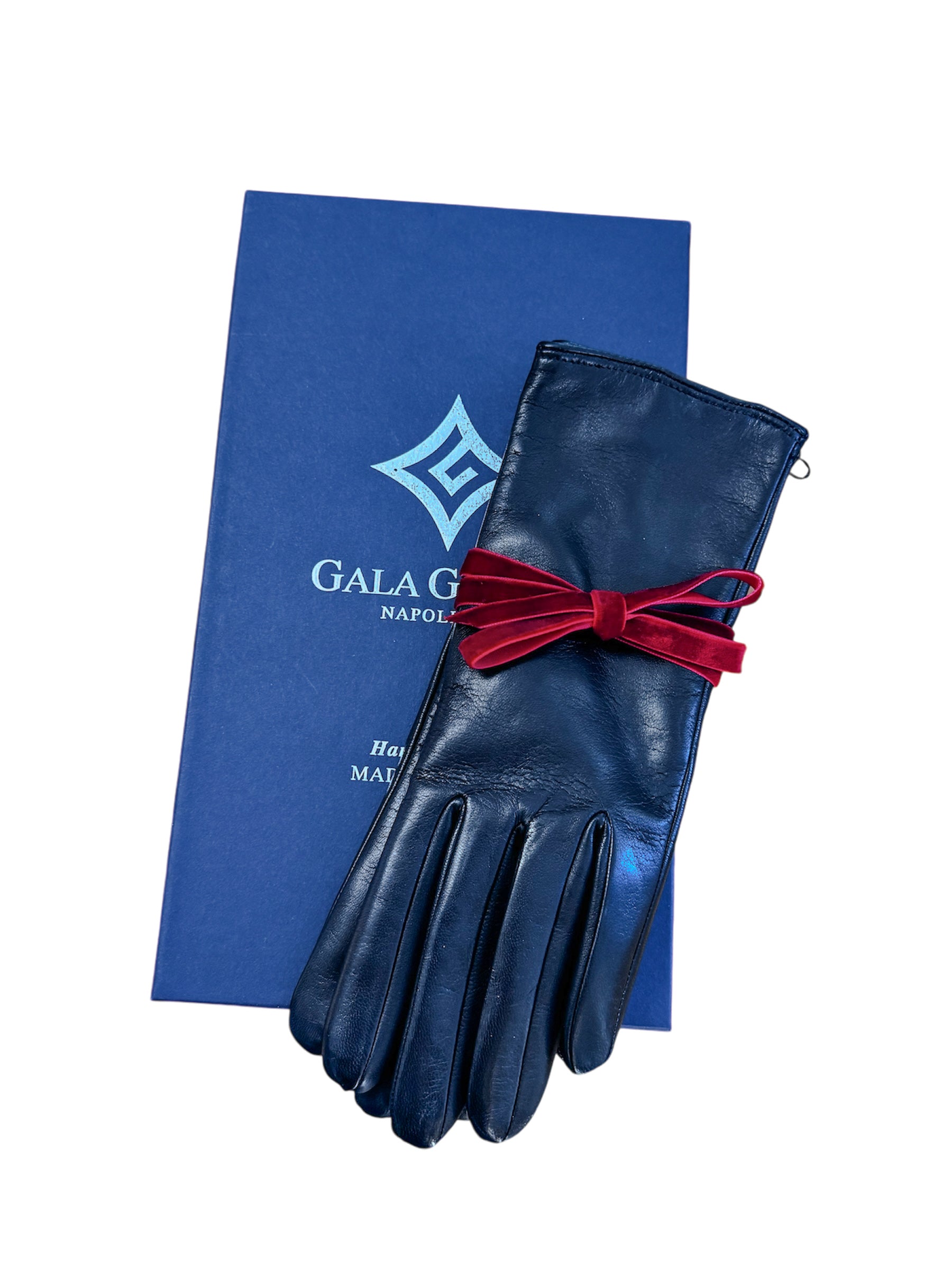 Little black leather gloves elegantly presented with a red velvet ribbon, resting on a blue Gala Gloves box.